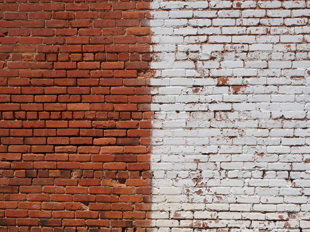 Brick wall with one half painted white