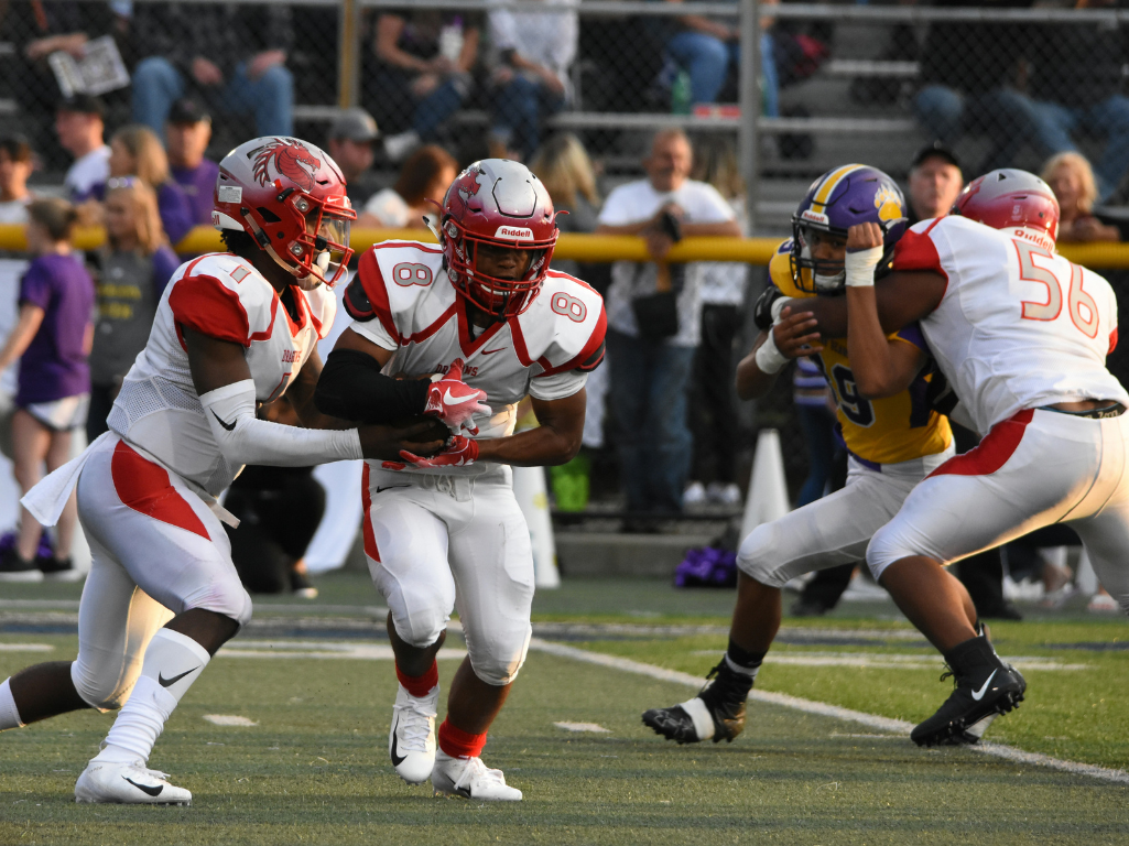 Quarterback handing off football to running back
